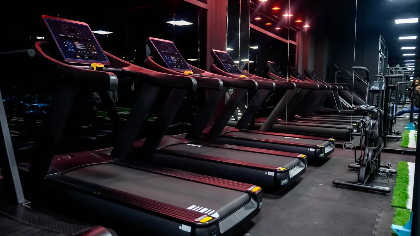 Al Khuwair 5 Elevate gym in Al Khuwair, Muscat — row of treadmills under red ceiling lighting in the private studio