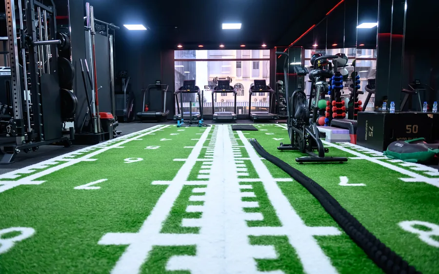 Elevate gym in Al Khuwair, Muscat &mdash; turf sprint lanes leading to treadmills and the street window of the private studio